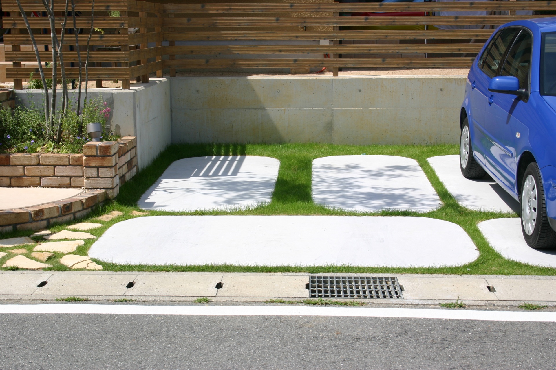 コンクリートと芝生のガレージスペース