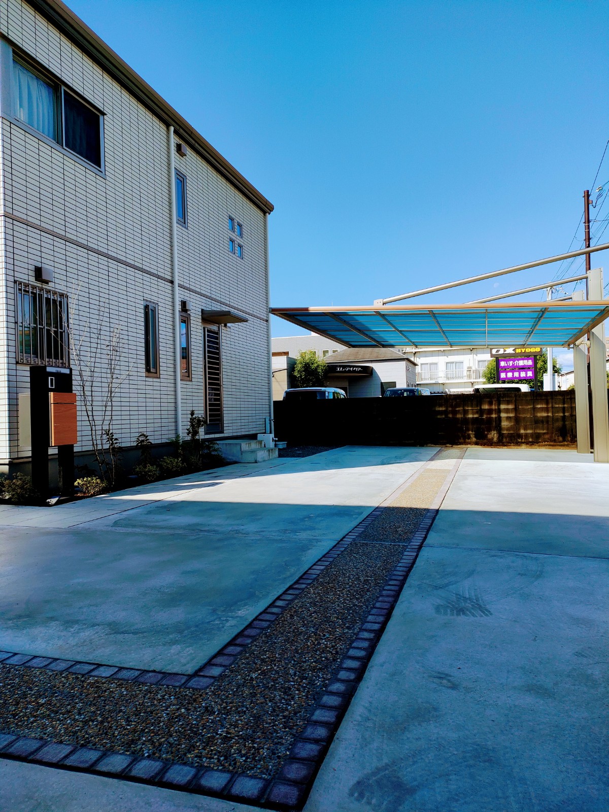モダン住宅外観に強いインパクトをあたえるシンプルカーポート　姫路市T様邸　洗出しのアクセントライン車庫土間