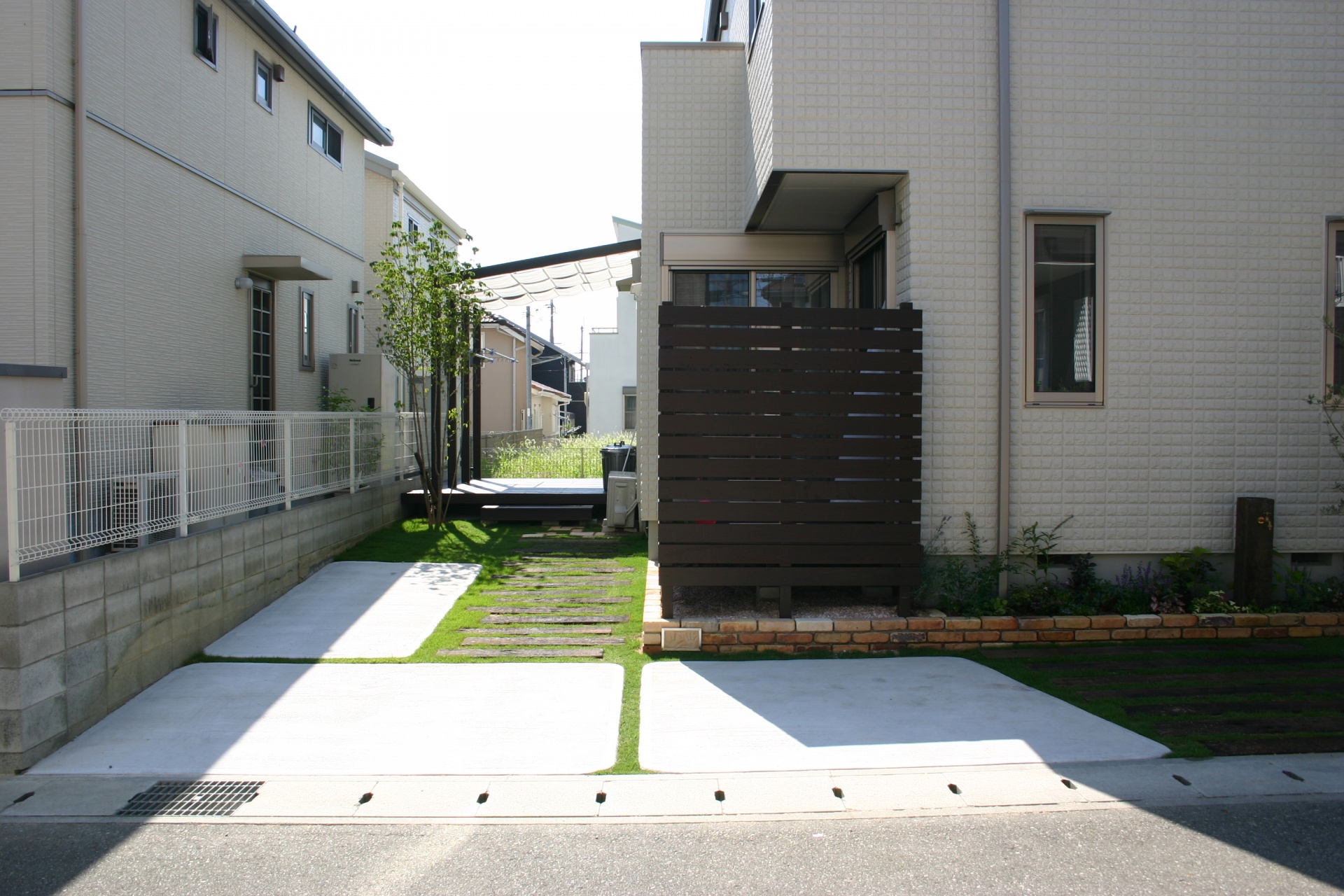 庭へのアプローチを兼ねたガレージ|枕木＋芝生